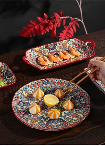 Close-up of Bohemian ceramic plates set with colorful patterns on dark wood table