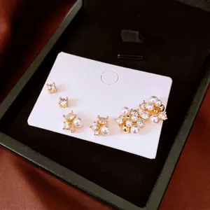 Ensemble de boucles d'oreilles fleurs en perles et zircons plaqués or 18 carats sur velours