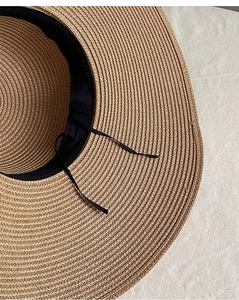 Détail du bord d'un chapeau de paille kaki avec bande de sudation noire et cordon réglable