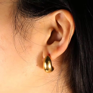 Dettaglio di orecchini a goccia placcati in oro 18K su una modella con finitura lucida