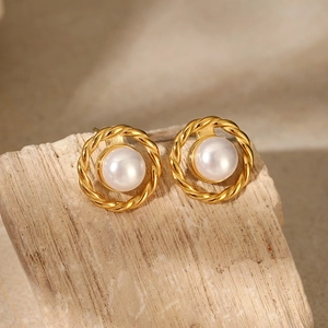Detailed close-up of golden twisted rope earrings with elegant white round pearls