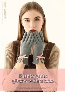 Détail de gants d'hiver gris avec un nœud rose et une fente au niveau du poignet
