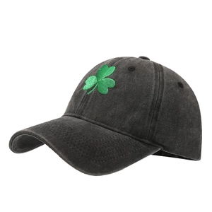 Retro washed cotton baseball cap in black with green shamrock embroidery on white background