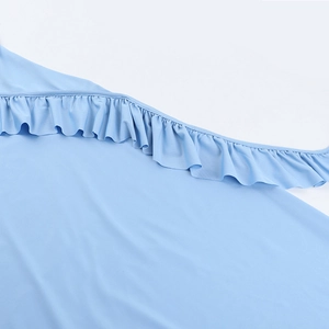 Gros plan détaillé des volants bleu clair et de la texture du tissu lisse de la robe