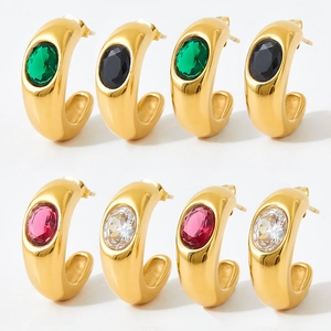 Detailed view of gold C-shaped chunky earrings set with multi-color oval gemstones