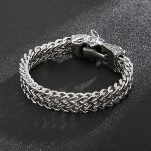 Macro view of detailed wolf head clasp on thick 316L stainless steel woven chain bracelet