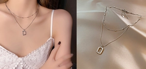 Detail of layered titanium steel necklace with textured rectangular pendant on silk