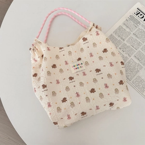 Dettaglio della borsa tote in tessuto waffle con stampe di orsi e manici a scacchi