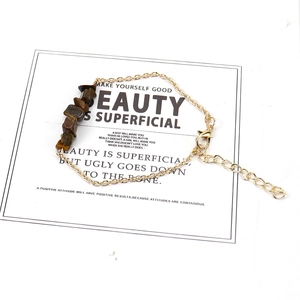 Detail view of natural tiger eye crystal beads on gold chain with adjustable clasp