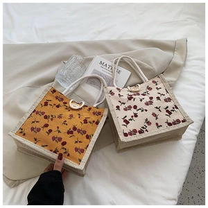 Detail of vintage floral canvas handbags with woven rope handles and button closure