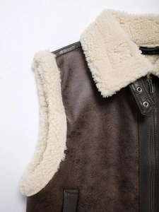 Detail of dark brown faux leather vest with soft cream shearling lining and high-quality zipper