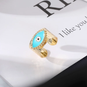 Hammered gold evil eye open ring with blue enamel inlay in a minimalist vintage style
