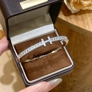 Silver H-shaped bracelet with cubic zirconia in a brown gift box on wooden table