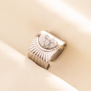 Detailed macro view of an adjustable wide stainless steel ring with radial textures