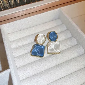 Irregular square and round resin earrings with golden wave metal base in blue and white