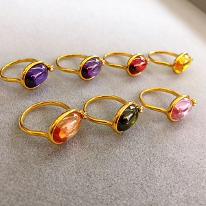 Set of 7 18K gold plated rings with colorful oval emerald cut gemstones on velvet