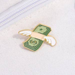 Detail of creative flying dollar enamel pin with wings on a canvas bag surface