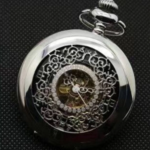 Details einer silbernen Skelett-Taschenuhr mit Strass-Lünette auf schwarzem Netzgrund