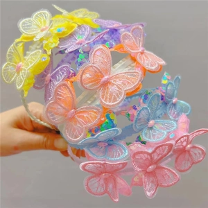 Detail showing various colorful lace butterfly headbands with sparkling sequins and woven bands