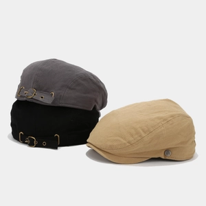 Detailed view of stackable cotton flat caps in grey, black, and khaki with metal buckles