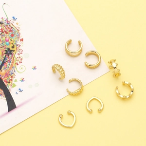 Detailed close-up of eight assorted vintage gold-plated metal ear cuffs for non-pierced ears