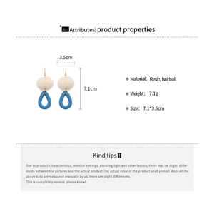 Detail showing cream hairball and blue resin waterdrop earrings with dimensions 7.1x3.5cm