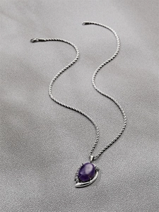 Detailed view of an oval purple gemstone pendant on a silver twisted rope chain