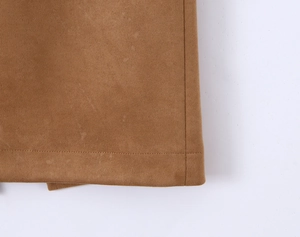 Macro view of dark camel faux suede skirt showing refined hem stitching and rich texture