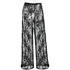 Close-up detail of sheer black lace fabric with floral embroidery on wide leg trousers