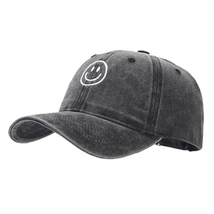 Washed dark grey baseball cap with white embroidered smiley face and curved brim
