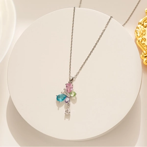 Macro detail of silver titanium butterfly pendant featuring colorful teardrop crystals