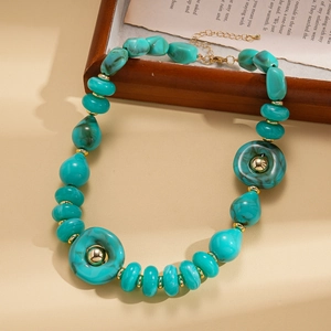 Detail of turquoise resin beads and golden metal spacers on a vintage sweater necklace