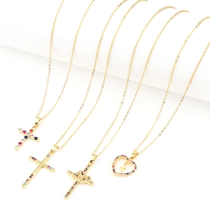 Detail of four 18K gold plated cross necklaces with colorful micro-inlaid stones