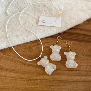 Creative resin bear jewelry set with gold-tone necklace and earrings on warm wood