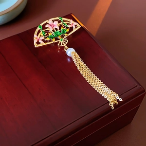 Macro detail of 18K gold plated fan brooch with pink enamel flowers and pearl tassels