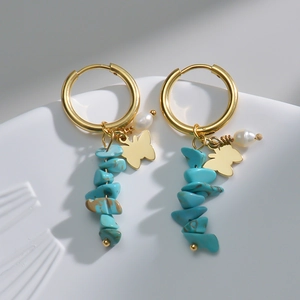 Detail of 14k gold earrings with blue turquoise beads, white pearls, and butterfly charms