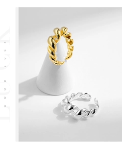 Detailed close-up of twisted rope texture rings in polished gold and silver finishes