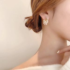 Elegant pearl cluster stud earrings in gold finish worn by a model for a chic look