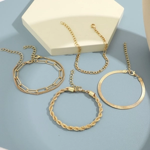 Close-up of four gold bohemian chain bracelets including Cuban and snake link styles