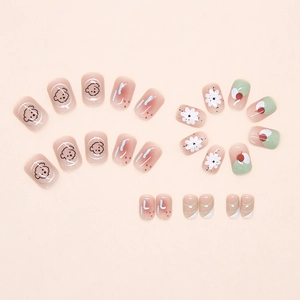 Detail of pink press-on nails with cute puppy, daisy, and cherry cartoon patterns