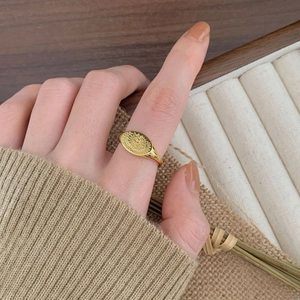 Detail shot of vintage 925 silver gold-plated sun seal ring worn by model
