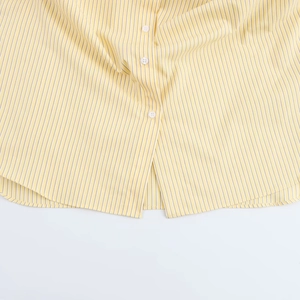 Detail of yellow striped shirt showing white buttons and soft cotton texture