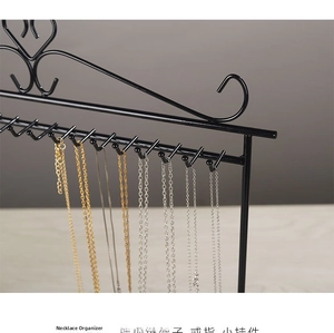 Detail of black iron jewelry organizer with heart motif and multiple U-shaped hooks
