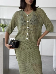Detail of avocado green knit hollow out cardigan showing white buttons and crochet texture