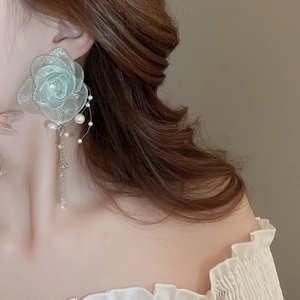 Detail of light green organza flower earrings with pearls and metal chain tassels