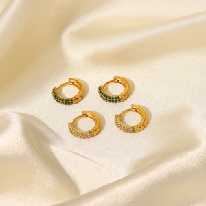 Detailed view of 18K gold plated hoop earrings with green and white zircon on silk