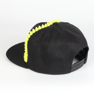 Λεπτομέρεια μαύρου καπέλου snapback με κίτρινα καρφιά από καουτσούκ και ρυθμιζόμενο κούμπωμα
