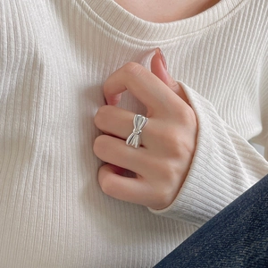 Detail of 925 sterling silver bow ring with polished mirror finish on model finger