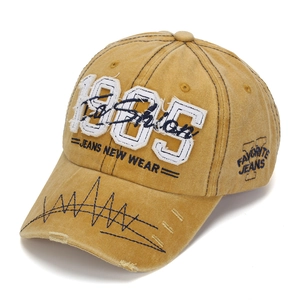 Close-up of vintage mustard baseball cap featuring 3D 1985 embroidery and distressed details