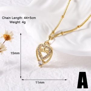 Detailed view of gold heart necklace with LOVE engraving and sparkling zircon inlays